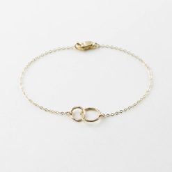 Pulseras doradas minimalistas. Circulitos es una delicada pulsera elaborada en plata de ley 925 bañada en oro 18k con dos pequeños anillos entrelazados.